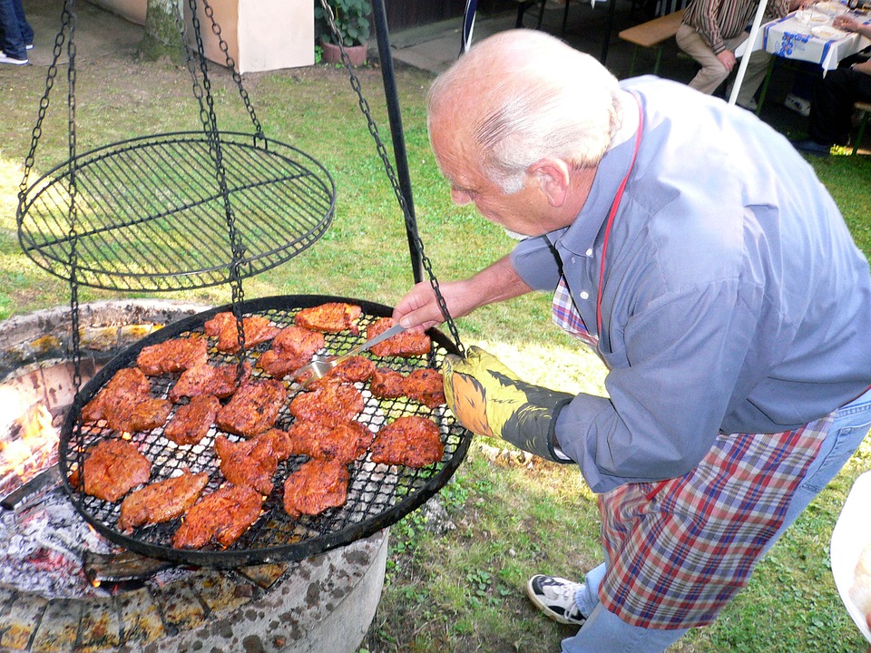 old man grilling meat